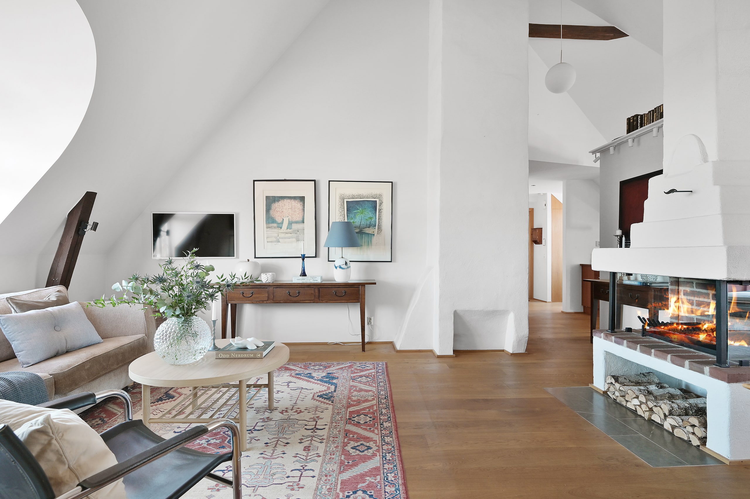 Ljust vardagsrum med öppen spis